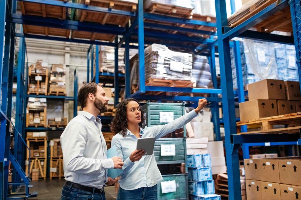 Two warehouse staff checking around