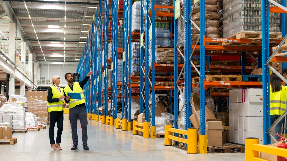 Two managers in safety vests discussing inventory