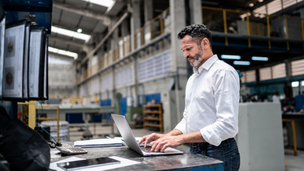 businessman using laptop in a warehouse